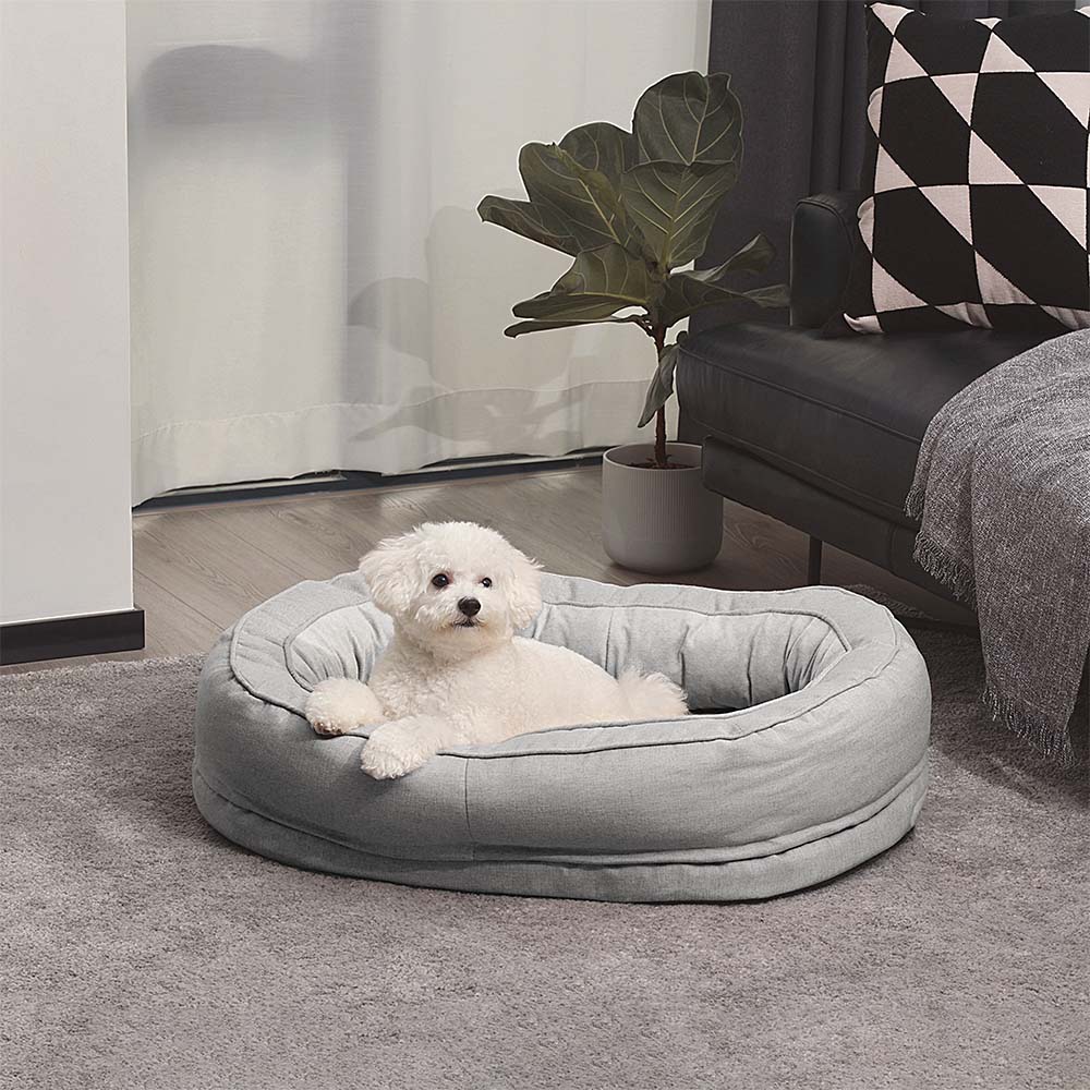 A small dog in the Grey Donut Dog Bed